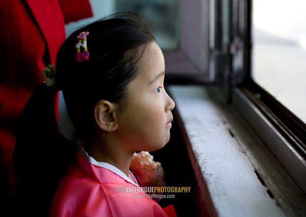 Young North Korean girl looking thru a window, Pyongan Province, Pyongyang, North Korea