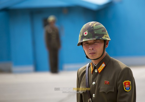 North Korean soldier wearing an helmet standing in front of the United Nations conference rooms on the demarcation line in the Demilitarized Zone, North Hwanghae Province, Panmunjom, North Korea