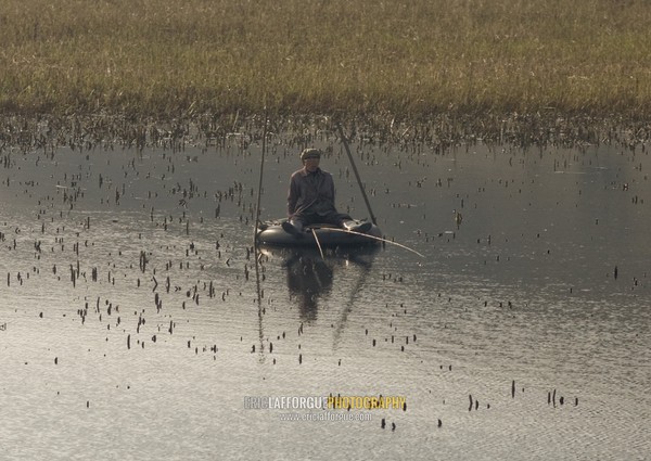 Old man fishing on a truck tyre in the countryside, South Pyongan Province, Nampo, North Korea