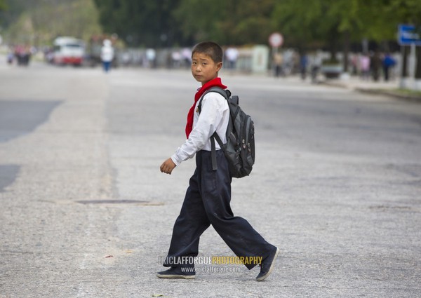 North Korean pioneer boy from the Korean children's union crossing a road, North Hwanghae Province, Kaesong, North Korea