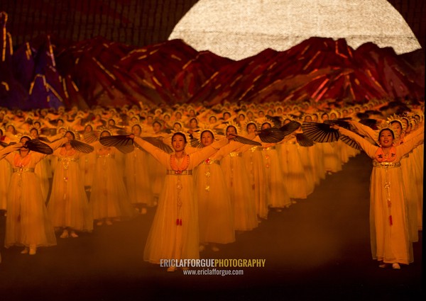 North Korean dancers in front of rising sun over mount Paektu made by children holding up boards during Arirang mass games in may day stadium, Pyongan Province, Pyongyang, North Korea