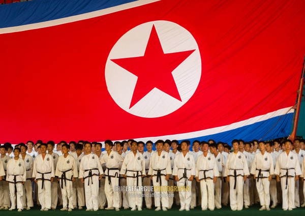 North Korean taekwondo team in front of a giant flag during the Arirang mass games in may day stadium, Pyongan Province, Pyongyang, North Korea