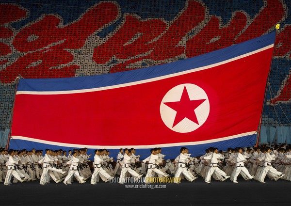 North Korean taekwondo team in front of a giant flag during the Arirang mass games in may day stadium, Pyongan Province, Pyongyang, North Korea