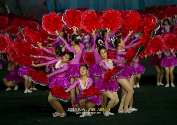 North Korean gymnasts holiding red flowers during Arirang mass games in may day stadium, Pyongan Province, Pyongyang, North Korea