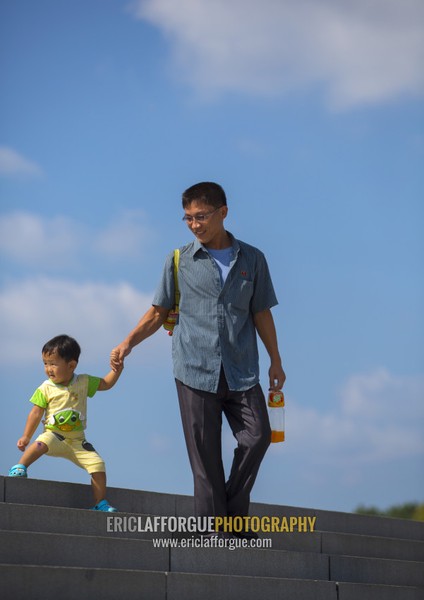 North Korean father and child on the stairs of the Juche tower, Pyongan Province, Pyongyang, North Korea