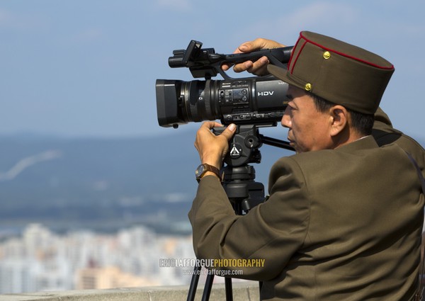 North Korean soldier filming Pyongyang from the top of Juche tower with a sony camera, Pyongan Province, Pyongyang, North Korea