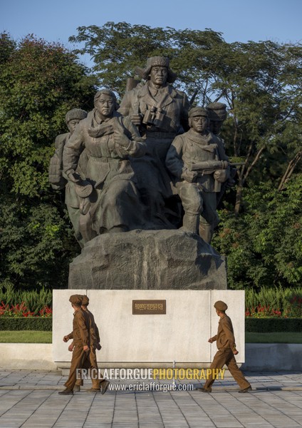 North Korean soldiers passing in front of a monument to the victorious fatherland liberation war museum, Pyongan Province, Pyongyang, North Korea