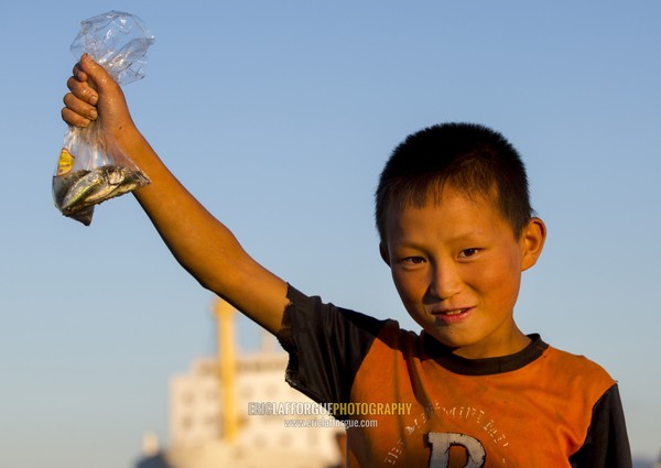 North Korean child boy showing fishes in a plastic bag he catched, Kangwon Province, Wonsan, North Korea