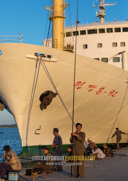 North Korean men fishing in front of a ship in the port, Kangwon Province, Wonsan, North Korea