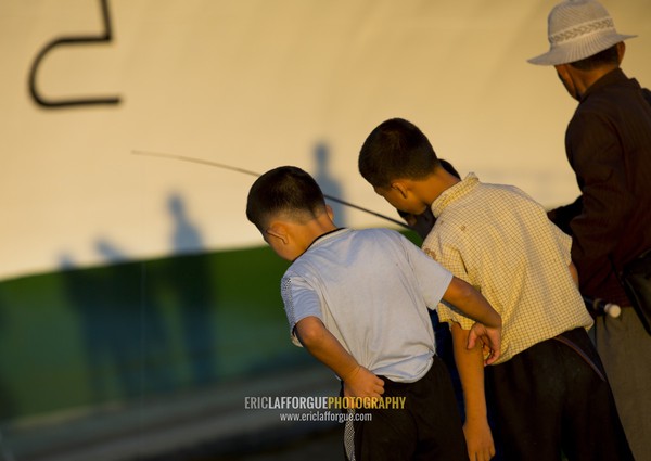 North Korean children fishing in the sea in front of a ship, Kangwon Province, Wonsan, North Korea