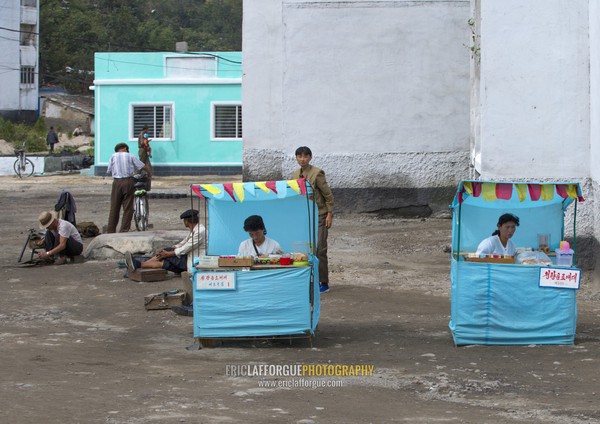 North Korean women selling food and drinks in little shops in the street, South Hamgyong Province, Hamhung, North Korea