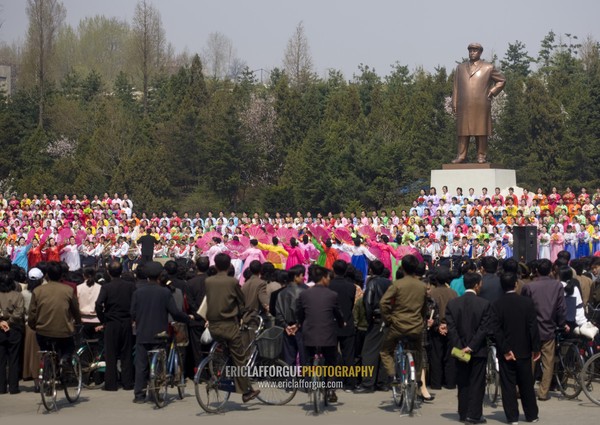 North Korean women dancing and singing in front of Kim il Sung statue in a village, South Pyongan Province, Nampo, North Korea