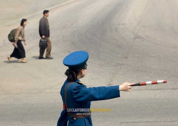 North Korean traffic security officer in blue uniform in the street, Pyongan Province, Pyongyang, North Korea