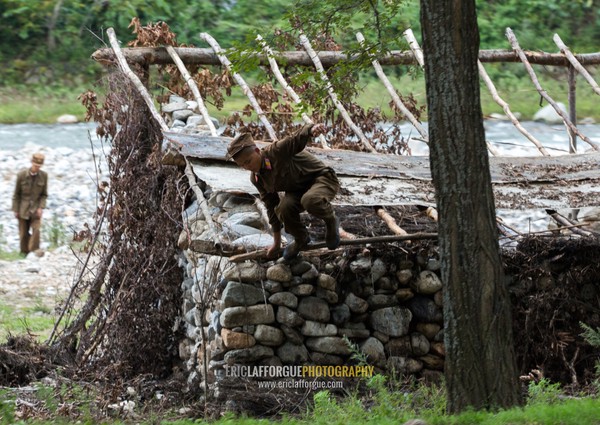 North Korean soldiers in a shelter made of stones along a river, Pyongan Province, Pyongyang, North Korea