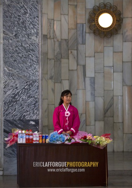 North Korean woman dressed in red choson-ot selling flowers at Mangyongdae children's palace, Pyongan Province, Pyongyang, North Korea