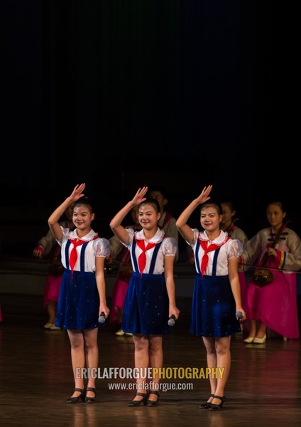 Young North Korean pioneers girls saluting during a show in Mangyongdae children's palace, Pyongan Province, Pyongyang, North Korea