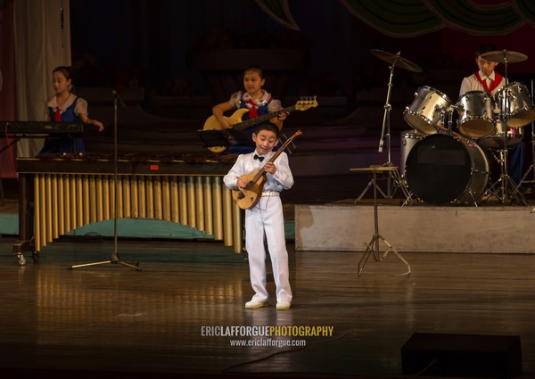 Young North Korean artist playing guitar during a show in Mangyongdae children's palace, Pyongan Province, Pyongyang, North Korea