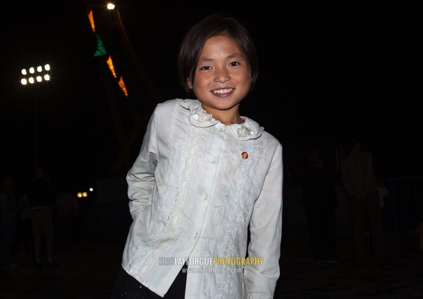 Smiling North Korean girl in the Kaeson youth park at night, Pyongan Province, Pyongyang, North Korea