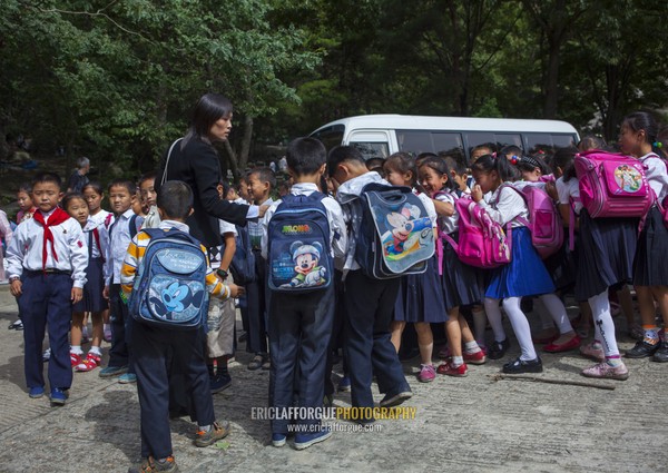 North Korean children with Mickey bags on their backs taking a bus, Pyongan Province, Pyongyang, North Korea