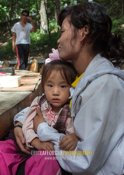 North Korean girl int he arms of her mother in a park, Pyongan Province, Pyongyang, North Korea