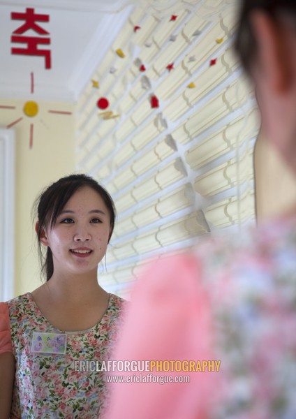 Portrait of a North Korean waitress looking at herself in a mirror, Pyongan Province, Pyongyang, North Korea