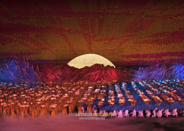 North Korean dancers in front of rising sun over mount Paektu made by children holding up boards during Arirang mass games in may day stadium, Pyongan Province, Pyongyang, North Korea