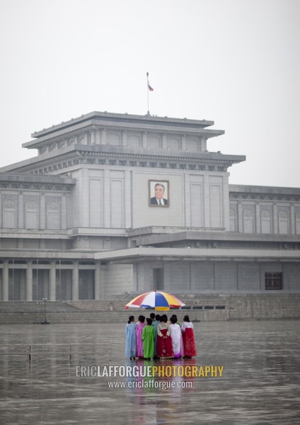 North Korean women under the rain in Kumsusan palace of the sun that serves as the mausoleum for Kim Il-sung and Kim Jong-il, Pyongan Province, Pyongyang, North Korea